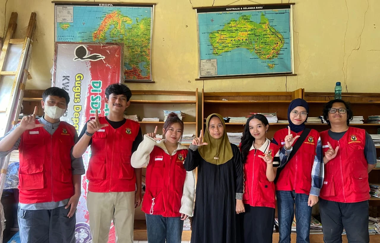 Tim KKN Tematik Literasi UNHAS Gelombang 114 berfoto bersama di perpustakaan SD Inpres Passuakkang, Desa Manuju, Kabupaten Gowa. Selama sebulan penuh, mereka mendedikasikan diri untuk menghidupkan kembali minat baca anak-anak melalui program inovatif seperti penataan perpustakaan dan kegiatan membaca bersama. Senyum yang terpancar bukan hanya kebanggaan atas selesainya program, melainkan juga harapan bahwa semangat literasi akan terus menyala di hati siswa-siswi. Kredit: Mahasiswa KKN Unhas.